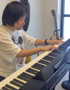 Individual served playing on a Casio keyboard.