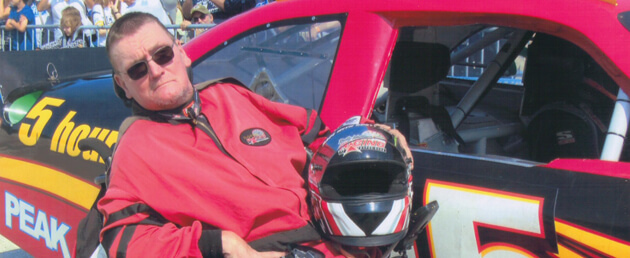Image of JR next to race car