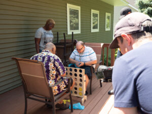 Two men on a home's back deck, playing the game Connect Four