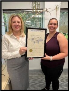 Kristin Hockert and Brianna Moolah holding a CARF accreditation certificate