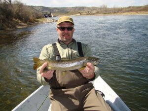 John Kehr in boat holding a fish he caught.
