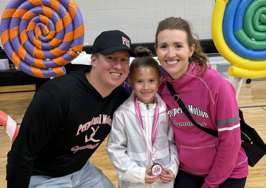Three people smiling at camera.
