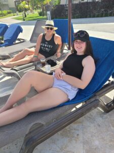 Two women sitting outside on lawn chairs.