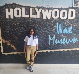 Christina posing in front of a sign that says Hollywood Wax Museum.