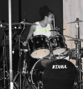 Christina drumming on a drum set.