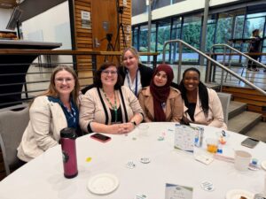 Group of five people sitting at a table.