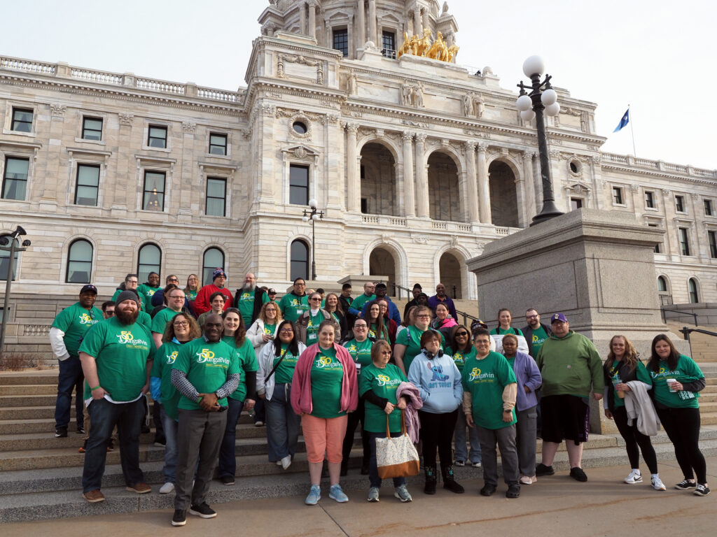 Large group of Dungarvin staff and persons served on the steps of the Minnesota State Capitol Building.