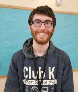 Andrew smiling and wearing a Club K sweatshirt.