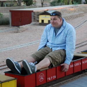 Greg Degel on a tiny train ride and making a funny face.