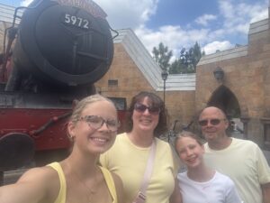 Monica Baty and her family standing in front of a stained glass window.