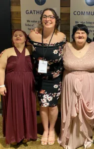 Three woman arm and arm posing for photo.