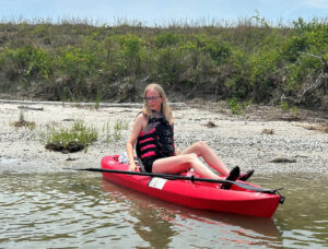 Suzanne Craig sitting on a kayak in a river.
