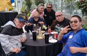 Five people sitting around a table smiling for the camera.