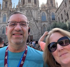 Lee-Ellen Bailey with her husband standing in front of a castle-like building in Spain.