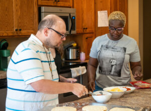 DSP helping person with cooking in the kitchen.