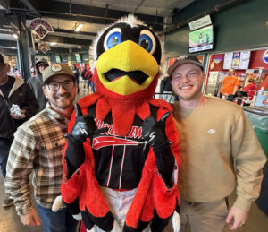 Sam Nelmark posing with a friend a bird mascot.