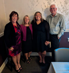 Sheri Butler standing and smiling with three other people.