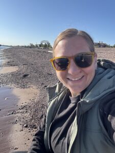 Kelly Sabel standing alongside the Lake Superior shore.